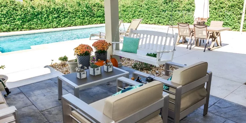 Patio seating looking out to pool in summer -