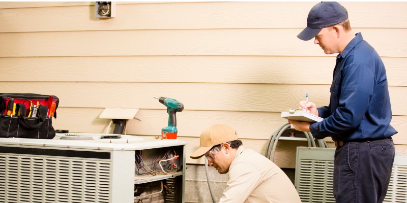 Two HVAC professionals doing maintenance