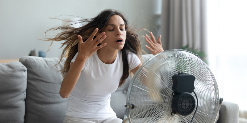 woman sitting in front of fan