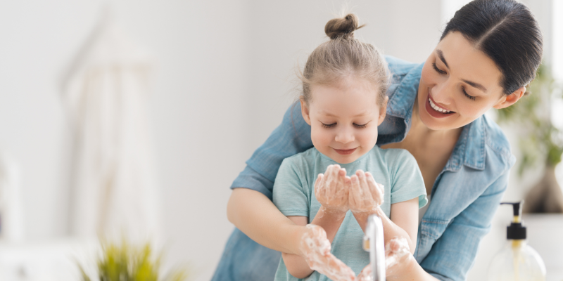 a mother and child using hot water for washing hands